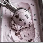 Scooping a perfect, creamy scoop of the finished Blackberry Chip Ice Cream.