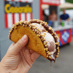 A hand holding a finished homemade Chocolate-Covered Ice Cream Taco.