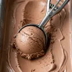 Scooping a perfect, creamy scoop of the finished homemade Chocolate Ice Cream.