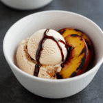 A scoop of Fire and Ice Cream served with a grilled peach.