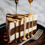 A slice of Ice Cream Cake being drizzled with chocolate and butterscotch sauce.