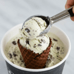 Scooping a perfect scoop of the finished homemade Mint Chip Ice Cream.