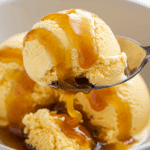 A spoonful of the finished Passion Fruit Ice Cream covered in caramel sauce.