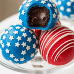 A stack of finished Patriotic Oreo Balls, one with a bite taken out.