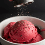 Grinding fresh black pepper over a scoop of Raspberry Buttermilk Sherbet.