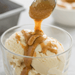 A scoop of Vegan Vanilla Ice Cream being topped with an almond butter swirl.