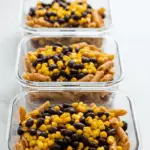 Three meal prep containers filled with the Black Bean and Corn Pasta Salad for healthy lunches.