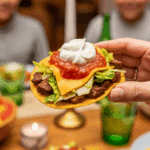A hand holding a finished Chipotle Beef Tostada.