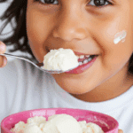 A happy child eating a bowl of homemade Cottage Cheese Ice Cream.