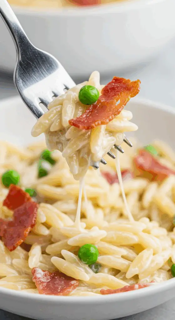 A forkful of the finished, creamy Orzo with Prosciutto and Peas.