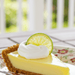 A perfect slice of Key Lime Pie with whipped cream being enjoyed on a sunny day.