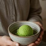 A person holding a simple bowl with a single scoop of homemade Matcha Ice Cream.