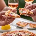 Two people holding slices of the finished Grilled Flatbread at a party.