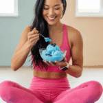 A person enjoying a bowl of High Protein Blueberry Cottage Cheese Ice Cream as a post-workout treat