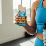 A hand holding a high-protein Keto Cottage Cheese Ice Cream Bar with a bite taken out.