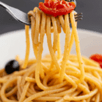 A forkful of the finished, creamy Pasta Puttanesca.