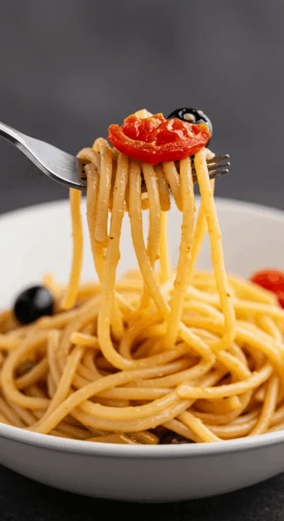 A forkful of the finished, creamy Pasta Puttanesca.