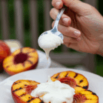 A person enjoying a dessert of Grilled Peaches with Gingersnaps at a summer barbecue.