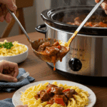 A person serving a large scoop of Slow Cooker Beef Paprikash from the pot.
