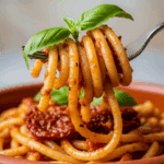A fork twirling a bite of the finished Sun-Dried Tomato Pesto Pasta.