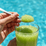 A person enjoying a cool, refreshing glass of Honeydew Sago by a swimming pool on a hot day.