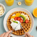 A person enjoying a healthy breakfast of High-Protein Cottage Cheese Waffles topped with fruit and yogurt.