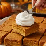 A platter of beautiful, square slices of homemade Sheet Pan Pumpkin Pie being served at a Thanksgiving party.