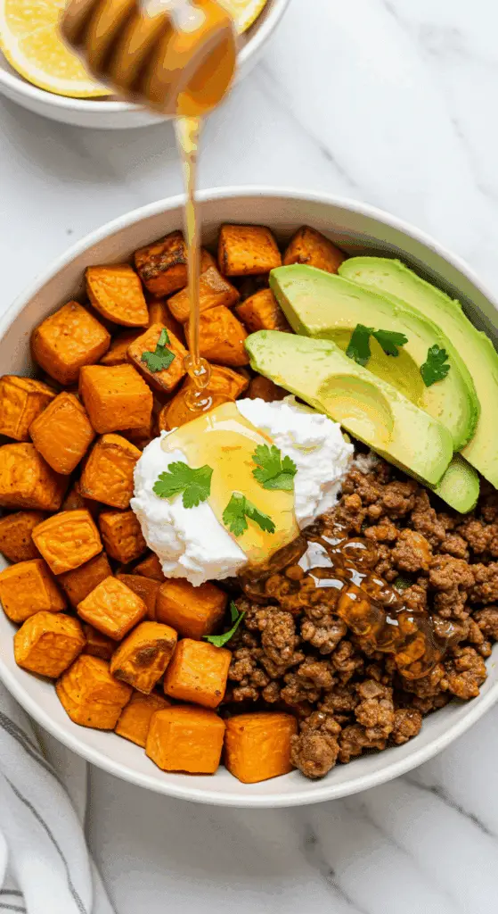 A beautiful, healthy, and colorful Hot Honey Ground Beef Bowl with sweet potatoes, cottage cheese, and avocado.