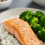 A beautiful and healthy dinner plate of homemade Maple Sesame Salmon served with fluffy white rice and steamed broccoli.