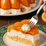 A delicious slice of homemade Orange Jello Salad being served on a plate at a happy family potluck.