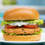A beautiful, homemade Salmon Patty served as a delicious salmon burger on a toasted brioche bun.