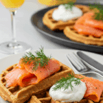 A beautiful plate of Savory Protein Waffles topped with smoked salmon, being served for an elegant brunc