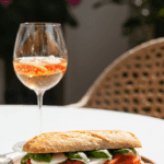 An elegant plate of a homemade, fresh Caprese Sandwich being enjoyed for a healthy lunch on a sunny patio.