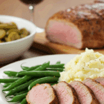 A classic dinner plate with a serving of homemade, Caramelized Pork Tenderloin, served with mashed potatoes and green beans.