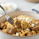 A beautiful bowl of homemade, healthy Pork and Orzo with feta being served for a delicious weeknight dinner.