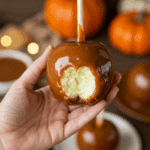 A beautiful, single, perfect, homemade Caramel Apple, with a thick, glossy, and deep amber-colored caramel coating on a crisp, green Granny Smith apple.