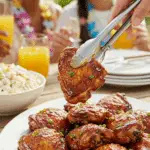 A large platter of homemade, sticky Huli Huli Chicken being served at a fun summer luau.