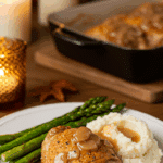 A classic dinner plate with a serving of homemade, crispy and saucy Braised Chicken, served with mashed potatoes and asparagus.