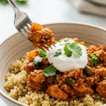 A beautiful bowl of homemade, healthy Mediterranean Turkey Skillet being served over a bed of quinoa for a delicious weeknight dinner.