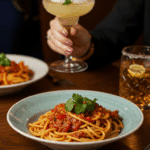 An elegant bowl of homemade, creamy, and spicy Six Pepper Pasta being served at a fun dinner party.