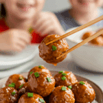 A cozy bowl of homemade, saucy Sweet and Sour Meatballs being served over rice for a casual family dinner.