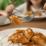 A cozy bowl of homemade, easy Sweet and Spicy Chicken served over a bed of fluffy white rice for a family dinner.