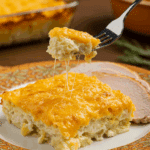 A beautiful plate of a homemade, elegant, and crispy All-Crust Scalloped Potatoes, being served with a thick slice of a roasted turkey at a Thanksgiving dinner.