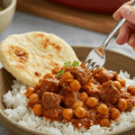 A cozy bowl of homemade, flavorful Beef and Chickpea Skillet served over rice with a piece of naan bread for a family dinner.
