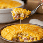 A cozy bowl of homemade, creamy, and cheesy-topped Cornbread Breakfast Casserole being served for a family holiday breakfast.
