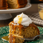 A beautiful plate with a homemade, festive, and moist slice of a Hot Buttered Rum Cake being served for a holiday dessert.
