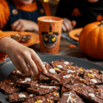 A large platter of homemade, spooky, and colorful pieces of Melting Witches Bark being served at a fun and casual Halloween party.
