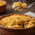 A cozy bowl of homemade, creamy, and crispy-topped Tuna Noodle Casserole being served for a family dinner.